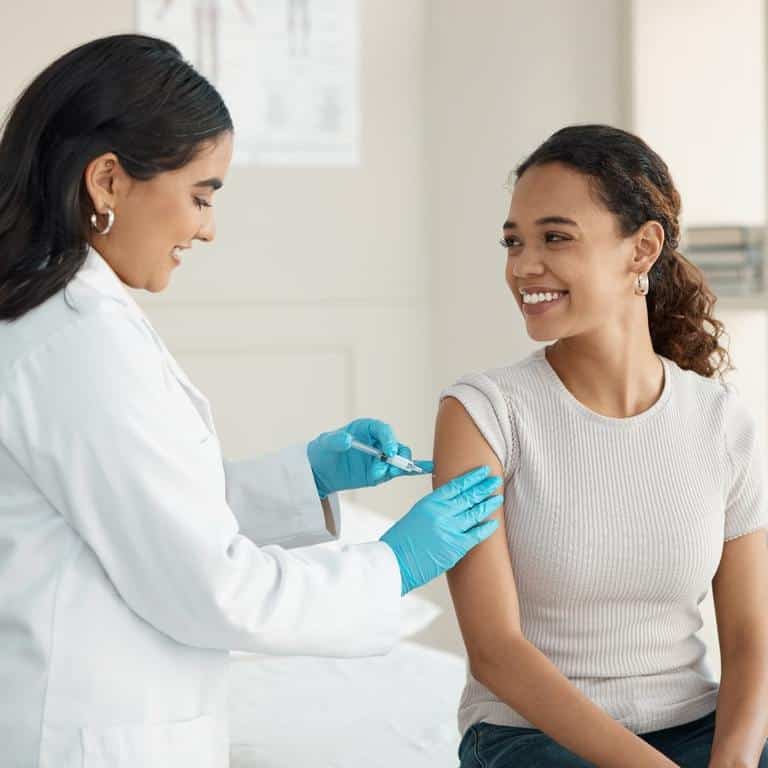 A Doctor At An Onsite Flu Clinic Giving An Injection To A Woman
