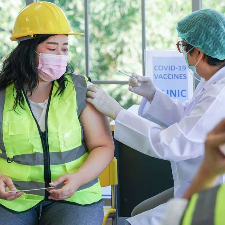 Woman At An Onsite Flu Clinic Getting A Vaccine