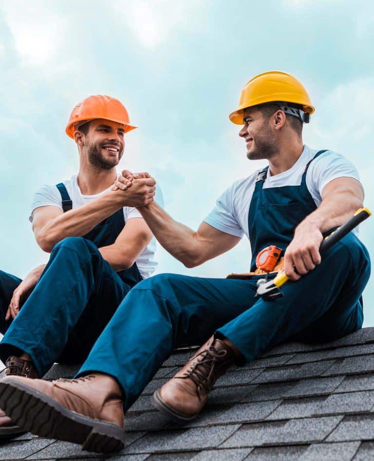 Two Workers In Hard Hats On A Rooftop Promoting Workplace Wellness